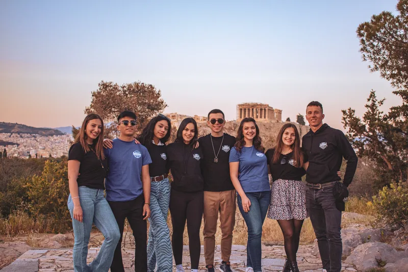 The Erasmus Life Athens crew lined up at sunset with the Parthenon and the city of Athens behind them